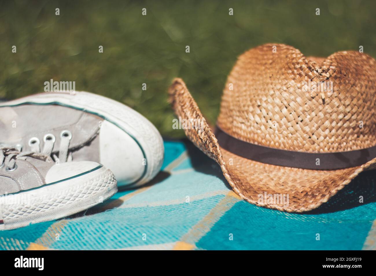 Picnic blanket with sneakers and straw hat Stock Photo Alamy