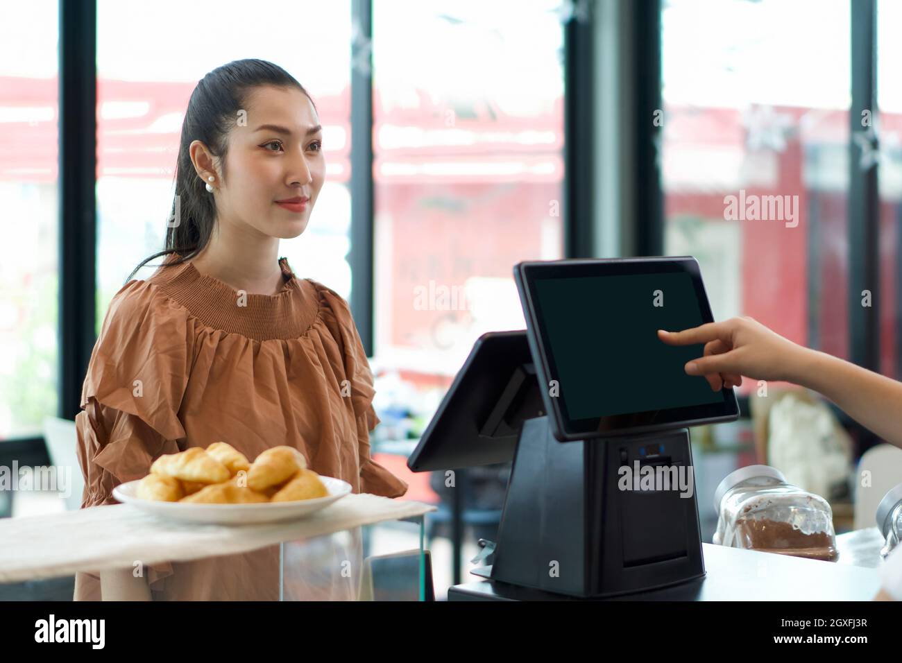 Young asian customer orders a beverage in front of cashier counter. Waiter  receive orders on the other side with a computer monitor. Morning atmospher  Stock Photo - Alamy