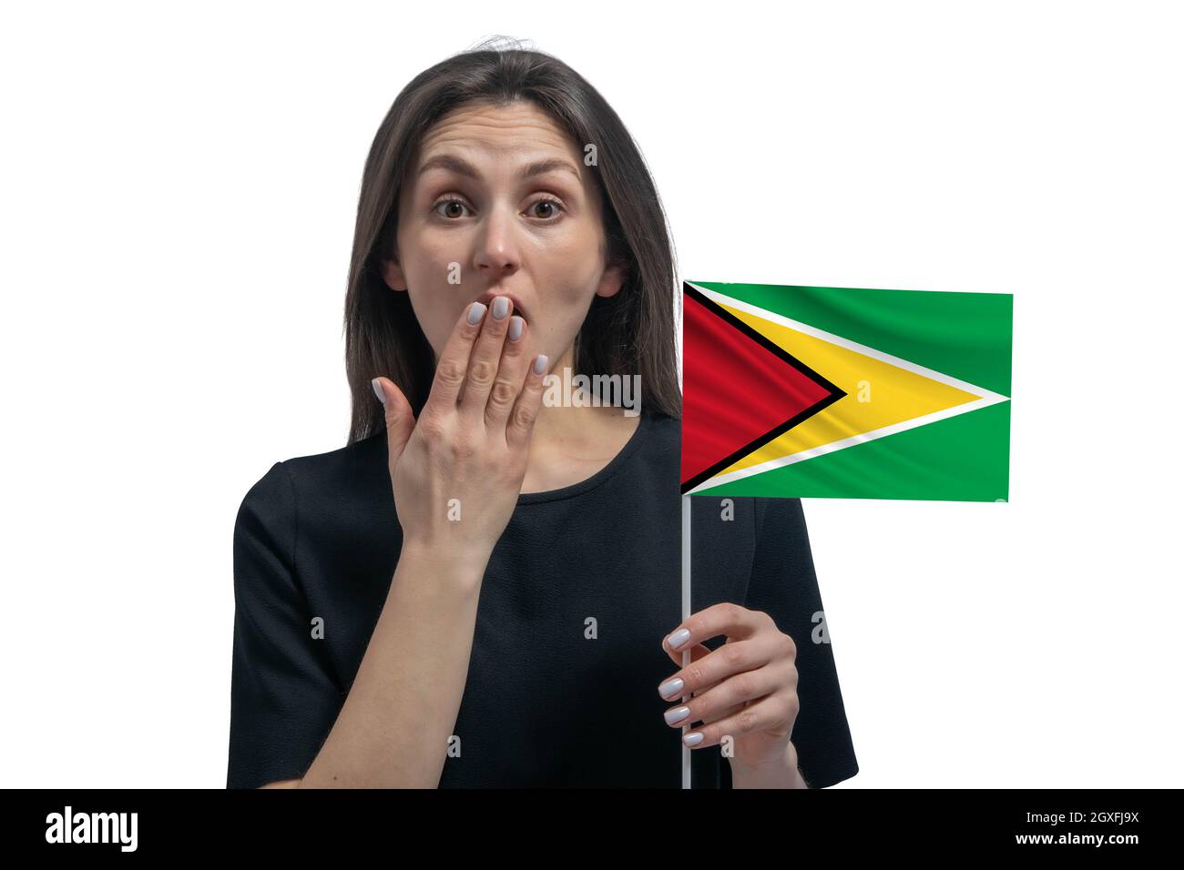 Happy young white woman holding flag of Guyana and covers her mouth with her hand isolated on a white background. Stock Photo