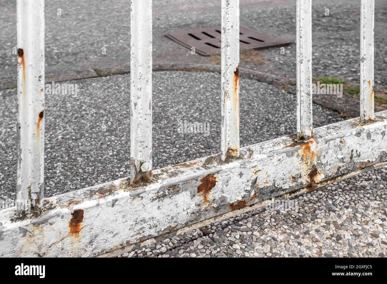 Rusty white gate on gray street background. Stock Photo