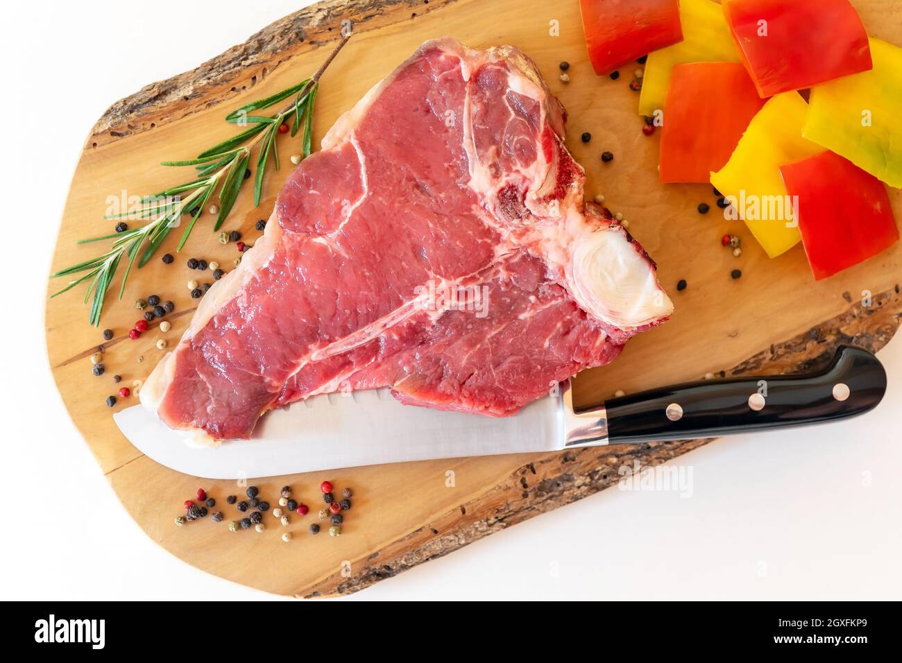 Florentine steak, preparation of raw meat, fillet and sirloin, with spices and peppers, for grilling. Stock Photo