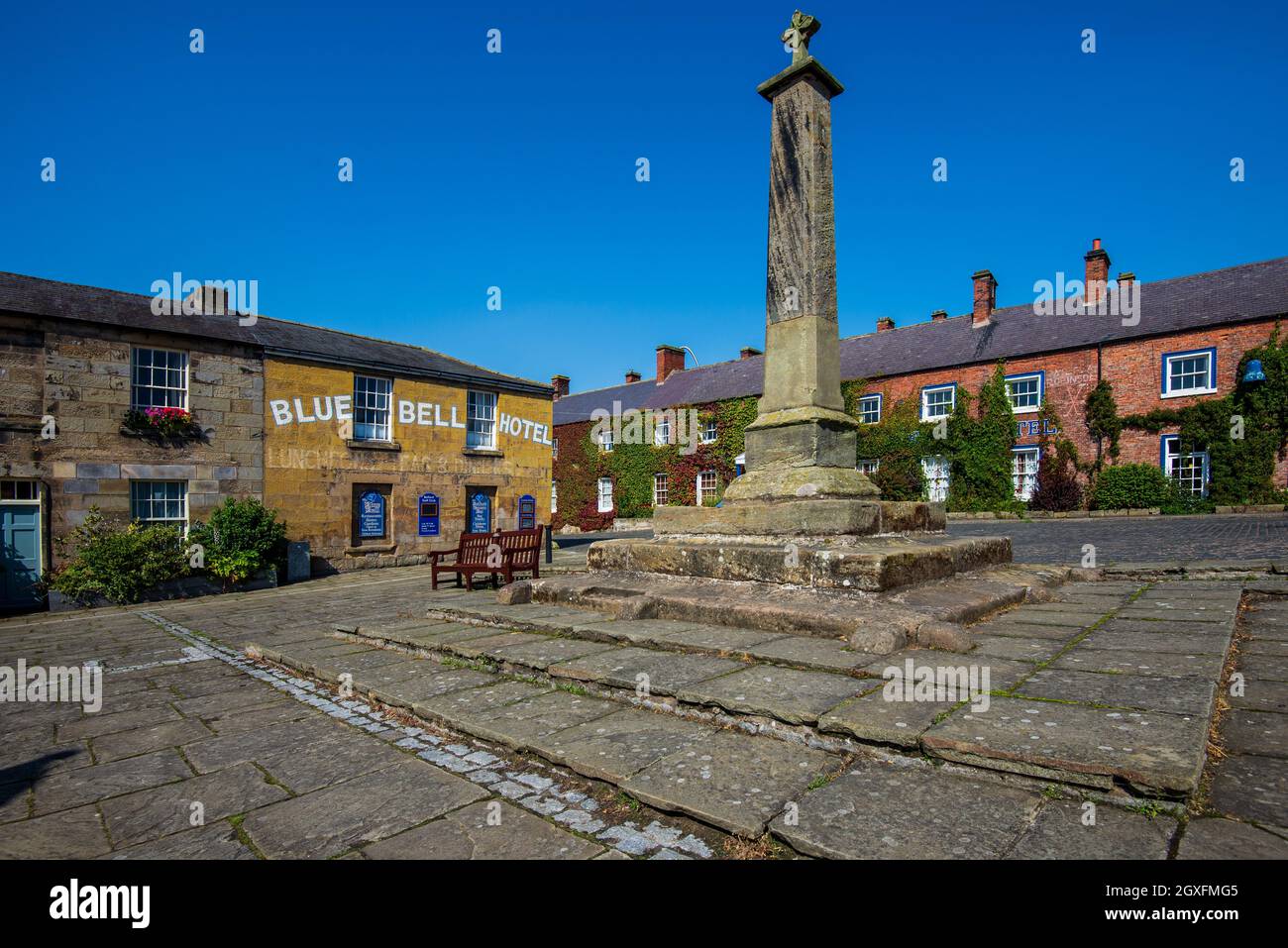 The market cross and Blue Bell Hotel, Belford, Northumberland, England, UK Stock Photo