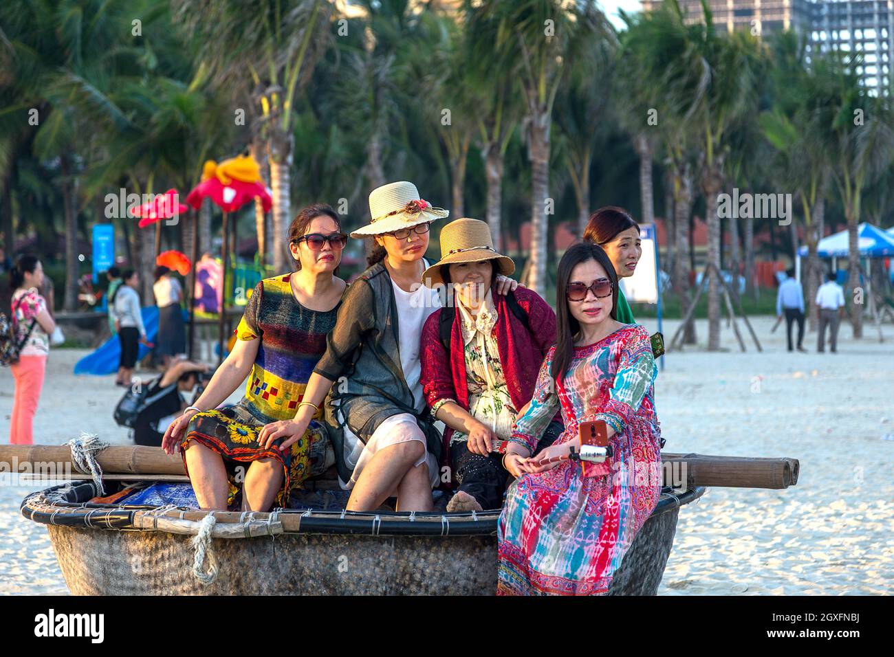 Group of women sitting in a round basket boat at China Beach, Da nang, vietnam. My Khe Beach Stock Photo