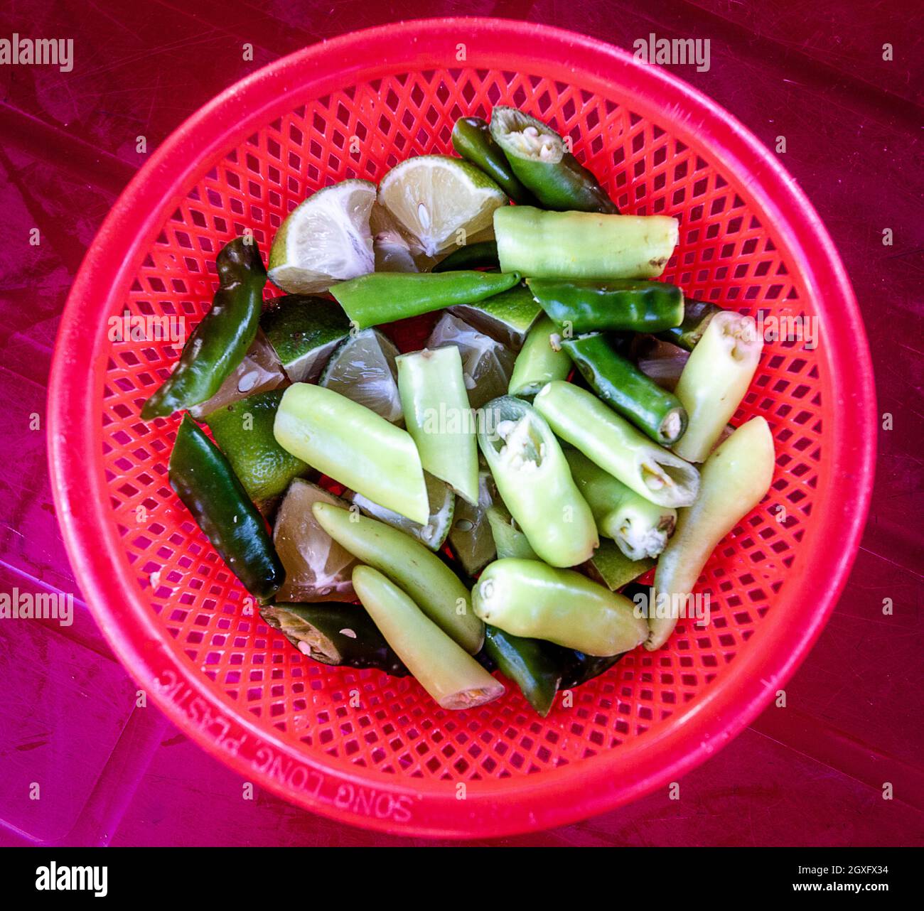 A Red basket on a red table with chili peppers for mi Quang Vietnamese