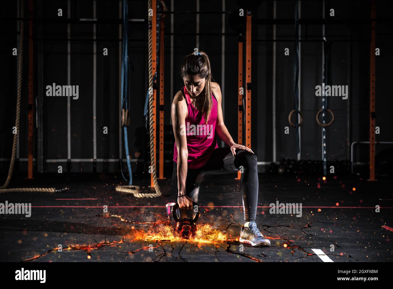 Young fitness female exercise with kettle bell. Caucasian woman doing  crossfit workout at gym. Stock Photo