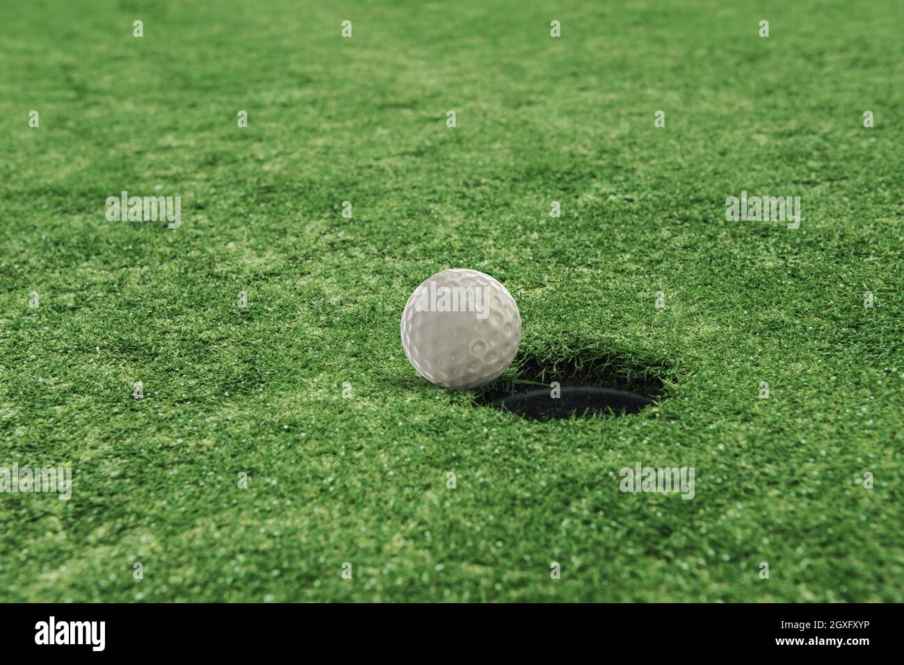 Golf ball near the hole in a green grass field Stock Photo - Alamy