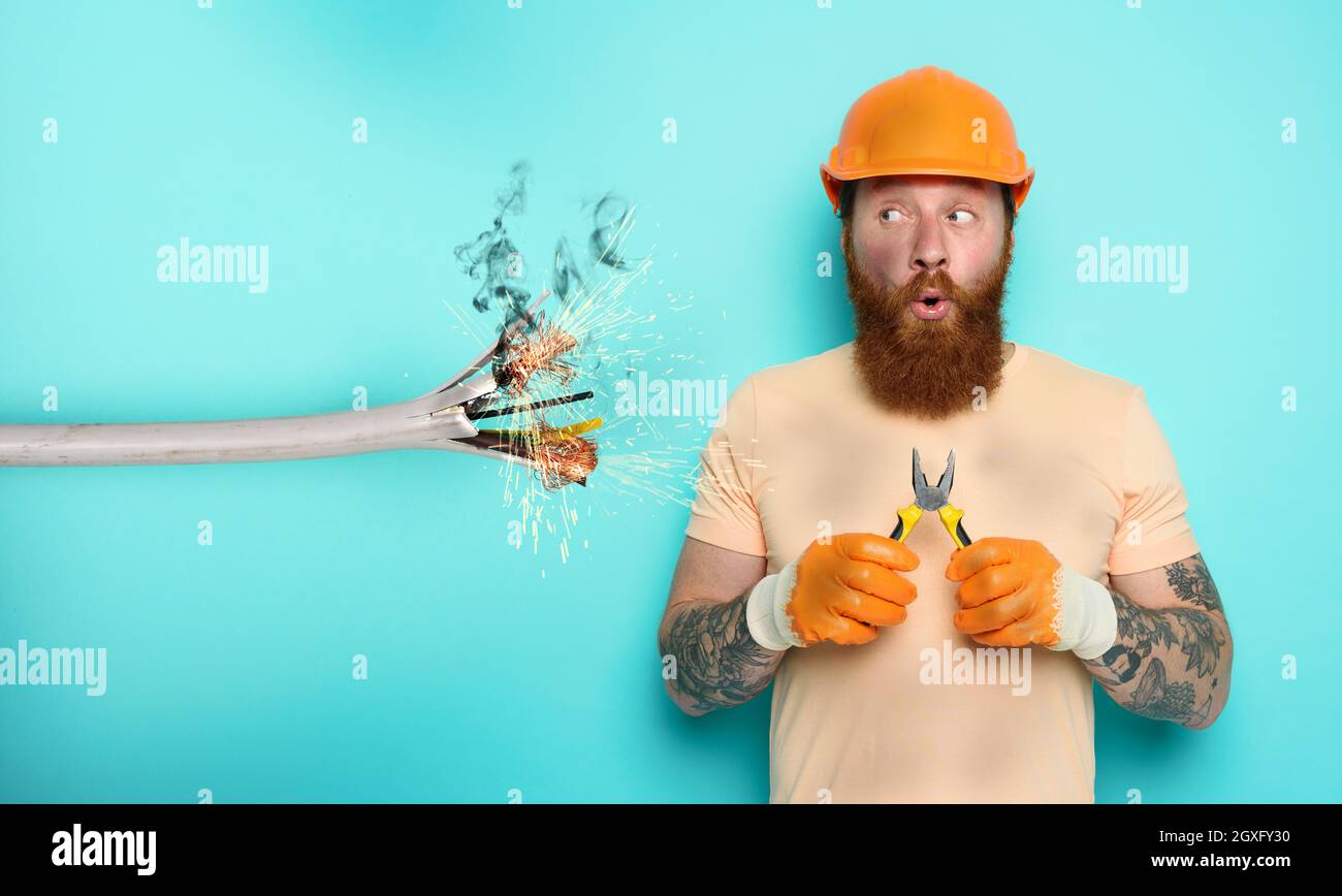 Incompetent worker electrician is unsure about his work Stock Photo