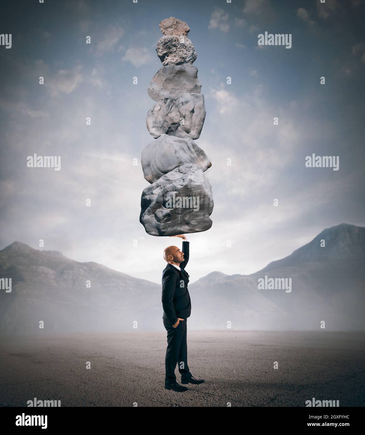 Businessman holds in one hand boulders stack Stock Photo - Alamy