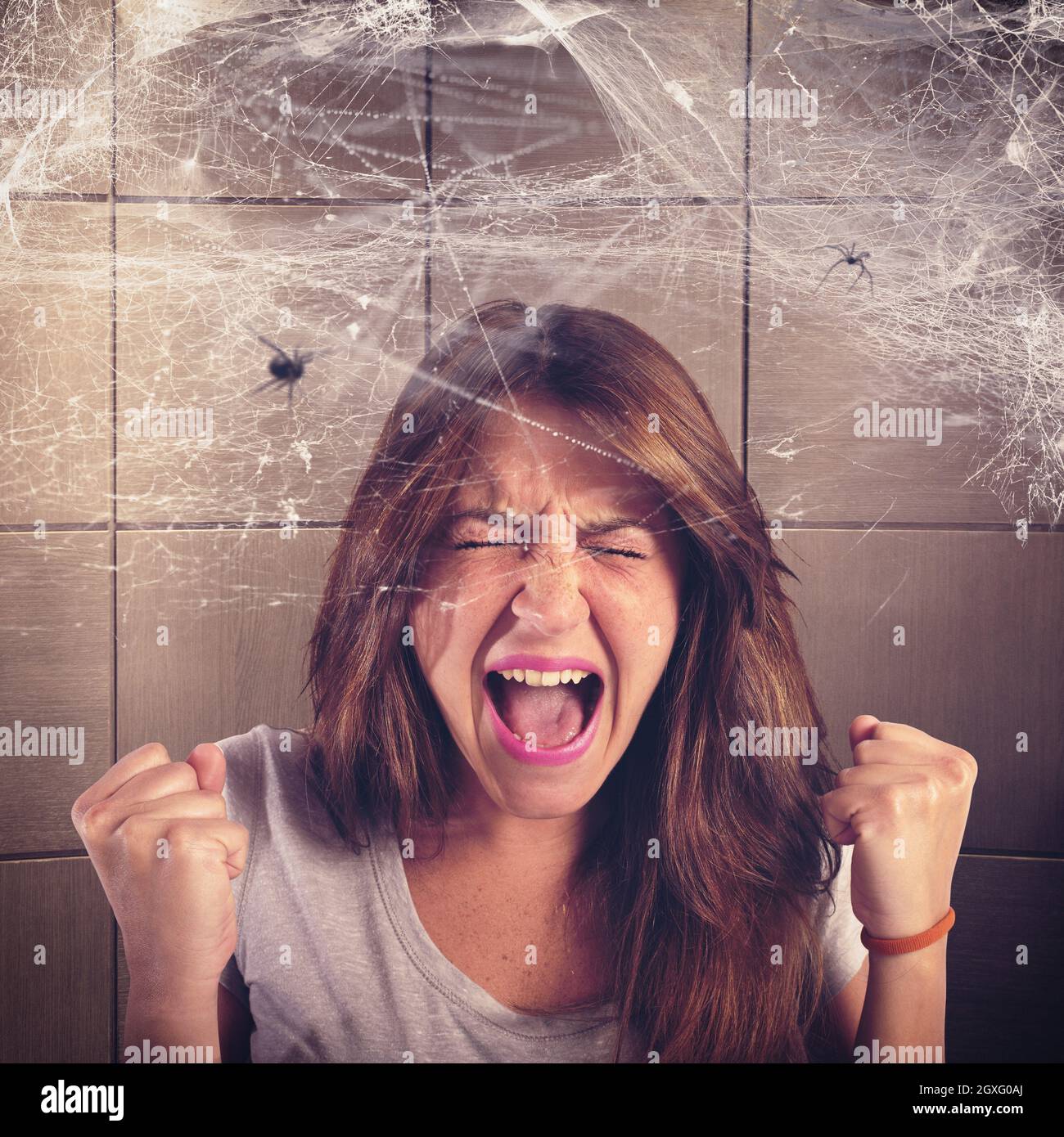 Girl screaming trapped in a spider web Stock Photo