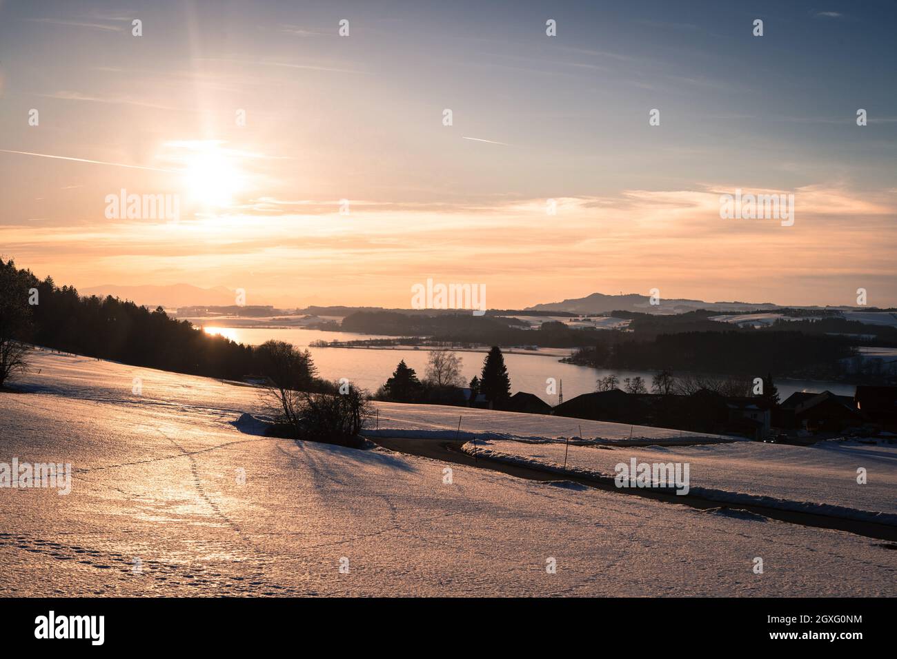 Lake, snowy fields and sundown: scenery at Wallersee, Austria Stock Photo