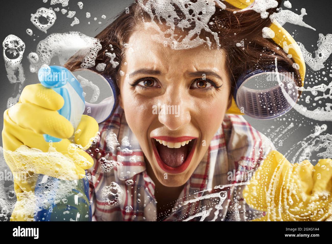 Desperate housewife screams while cleaning the glass Stock Photo