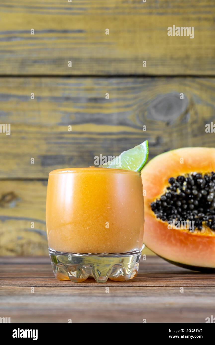 Glass of Papaya Caliente fruity rum cocktail with fresh papaya fruit