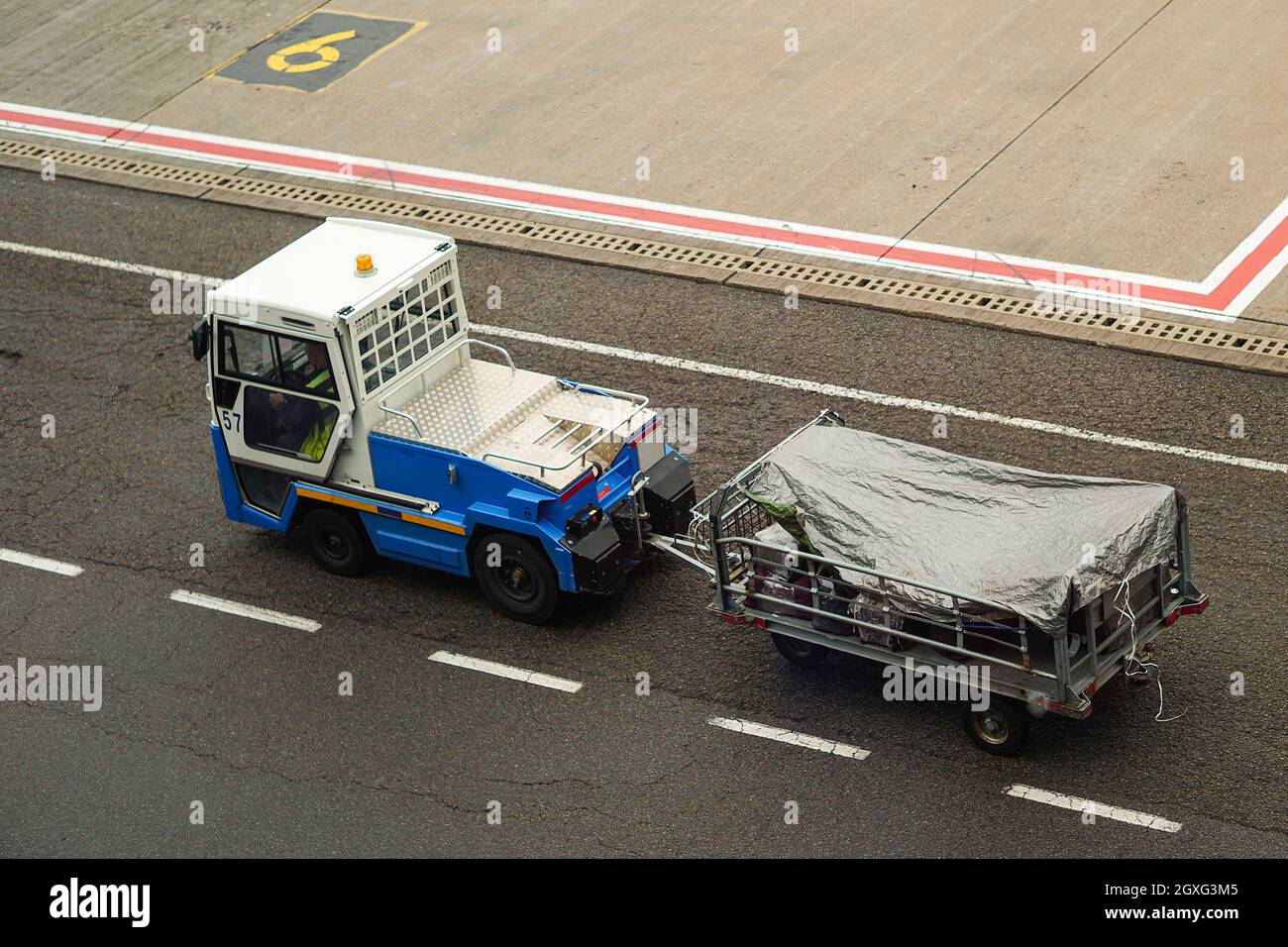 International Airport. Luggage traffic on an electromobile to the airplane. Stock Photo