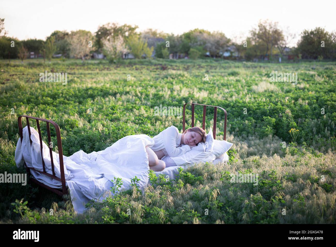 girl sleeping in the bed in a green field. healthy sleep in nature