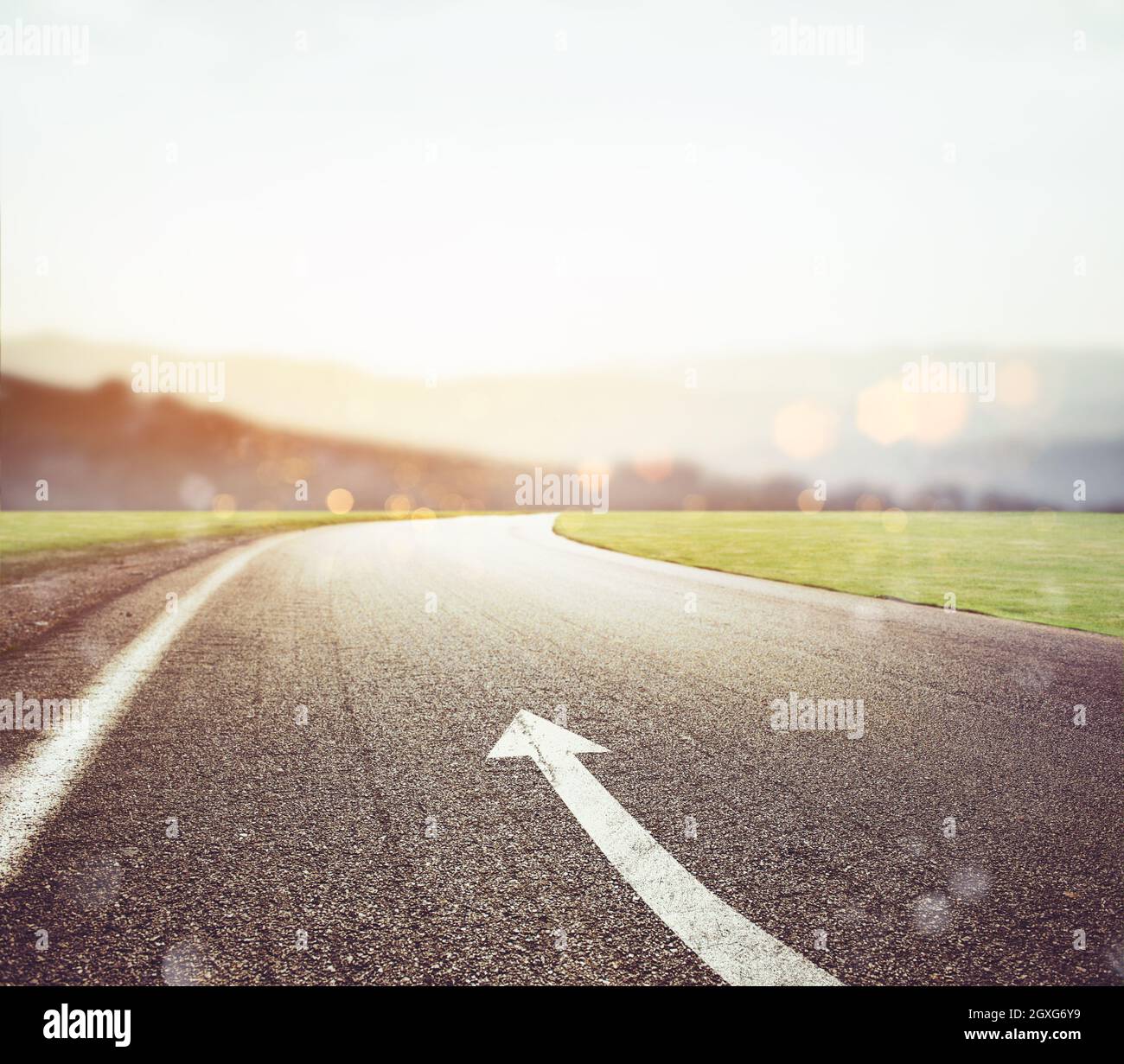 Road with arrow sign on the asphalt with sun in front. Concept Stock ...