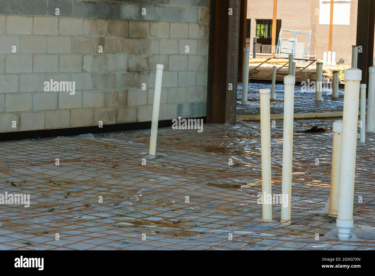 Plastic vapor barrier on slab with plumbing pvc pipes of foundation