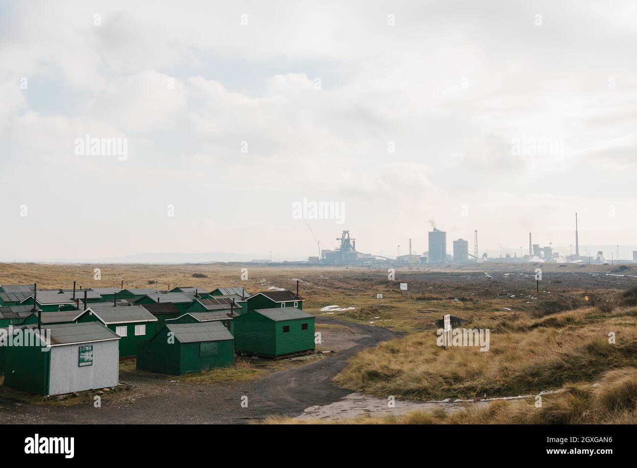 Petrochemical works and Tata Steel works juxtapositioned with the green fishermens huts at Paddys Hole, South Gare. Stock Photo