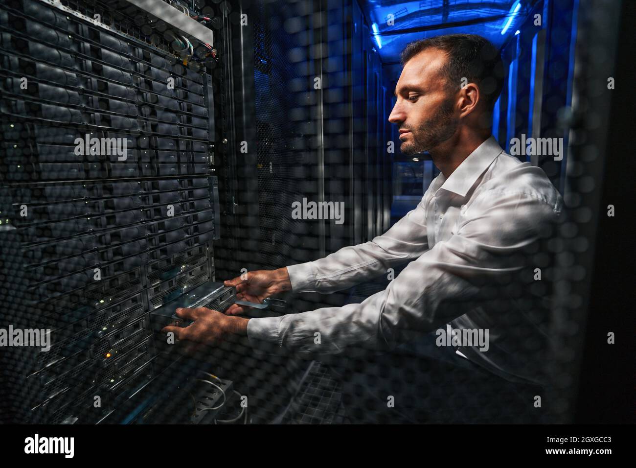 Professional European network engineer operating in server room Stock Photo