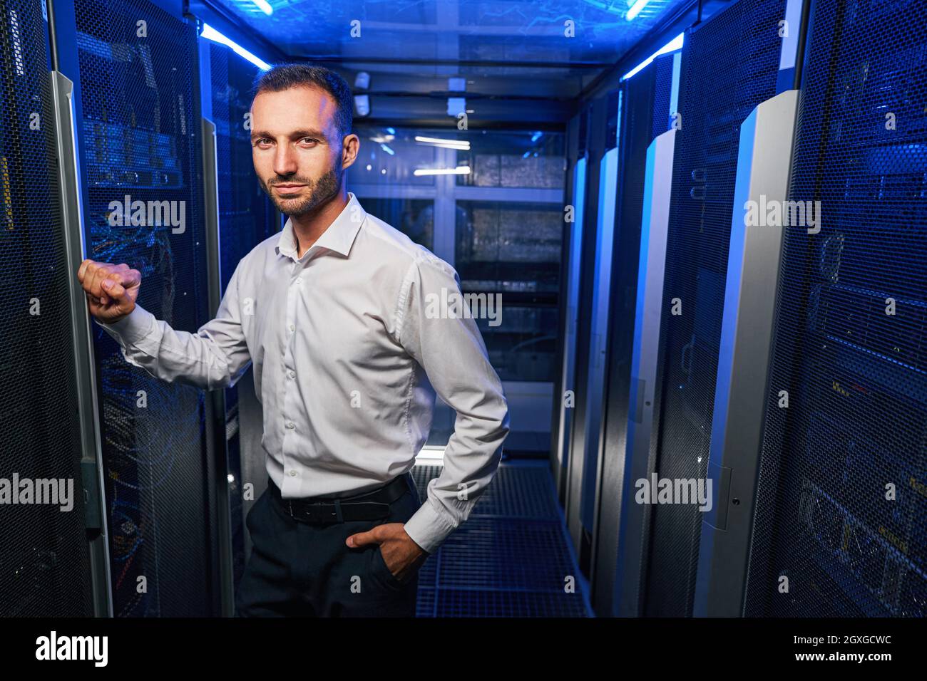 Bearded handsome maintenance administrator working with tech it equipments in data center Stock Photo