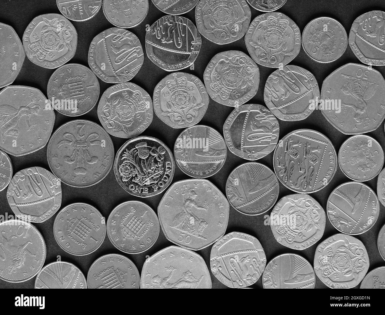 Pound coins money (GBP), currency of United Kingdom, over black background in black and white Stock Photo