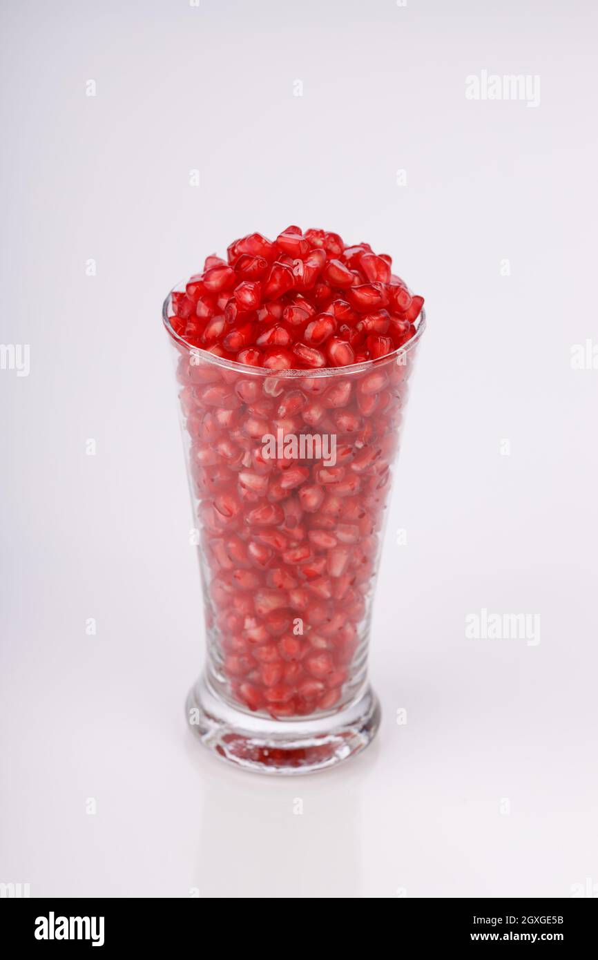 Fresh Pomegranate seed arranged in a  glass container with  white background, isolated. Stock Photo