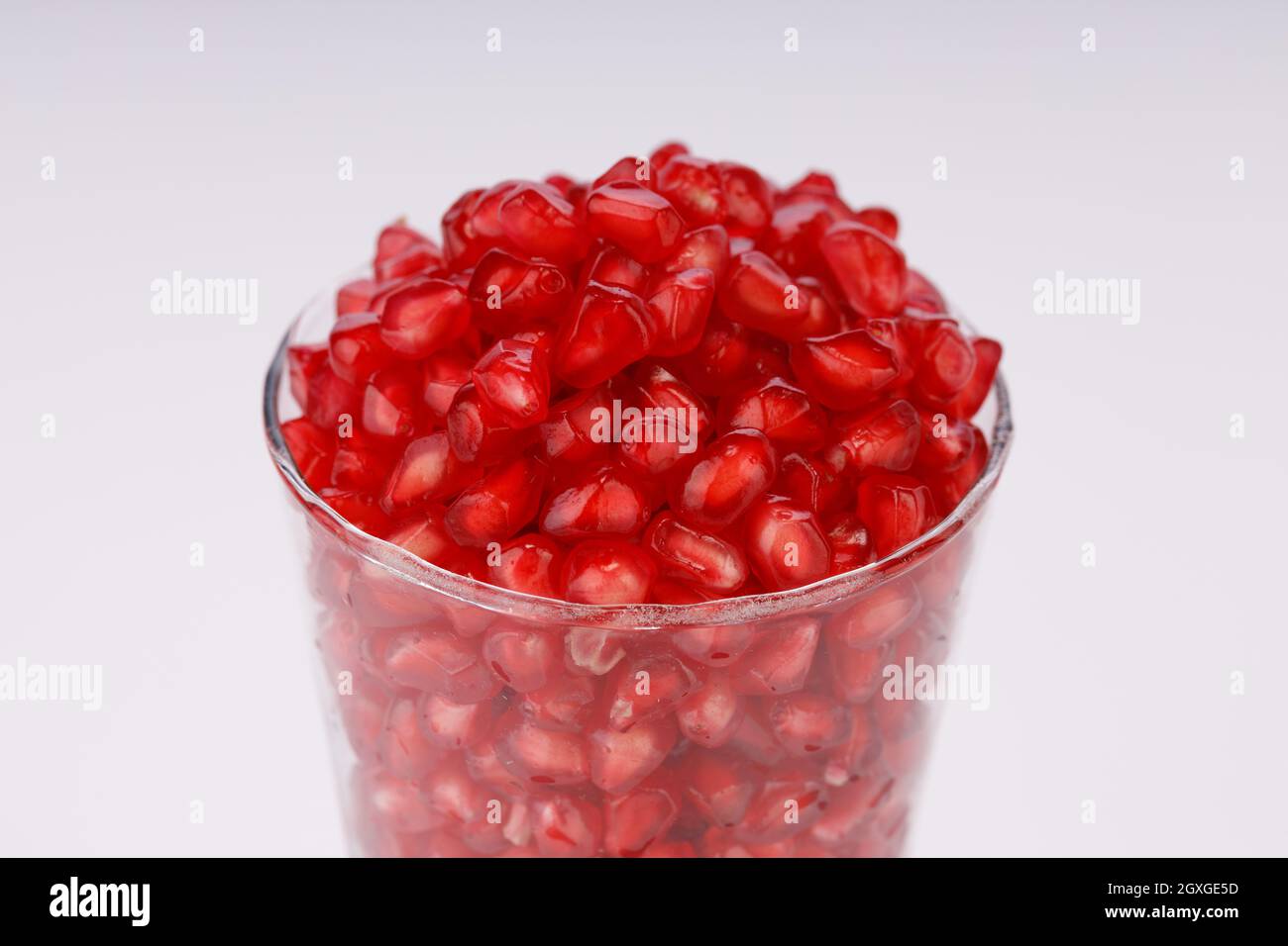 Fresh Pomegranate seed arranged in a  glass container with  white background, isolated. Stock Photo