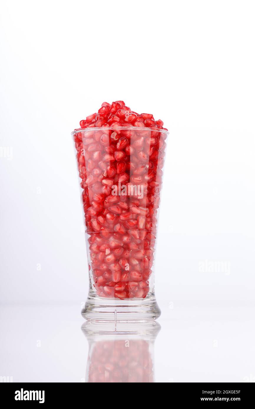 Fresh Pomegranate seed arranged in a  glass container with  white background, isolated. Stock Photo