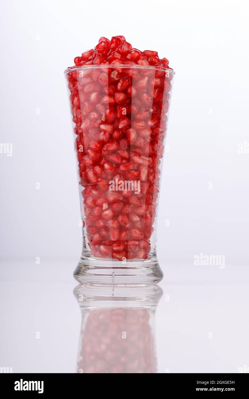 Fresh Pomegranate seed arranged in a  glass container with  white background, isolated. Stock Photo