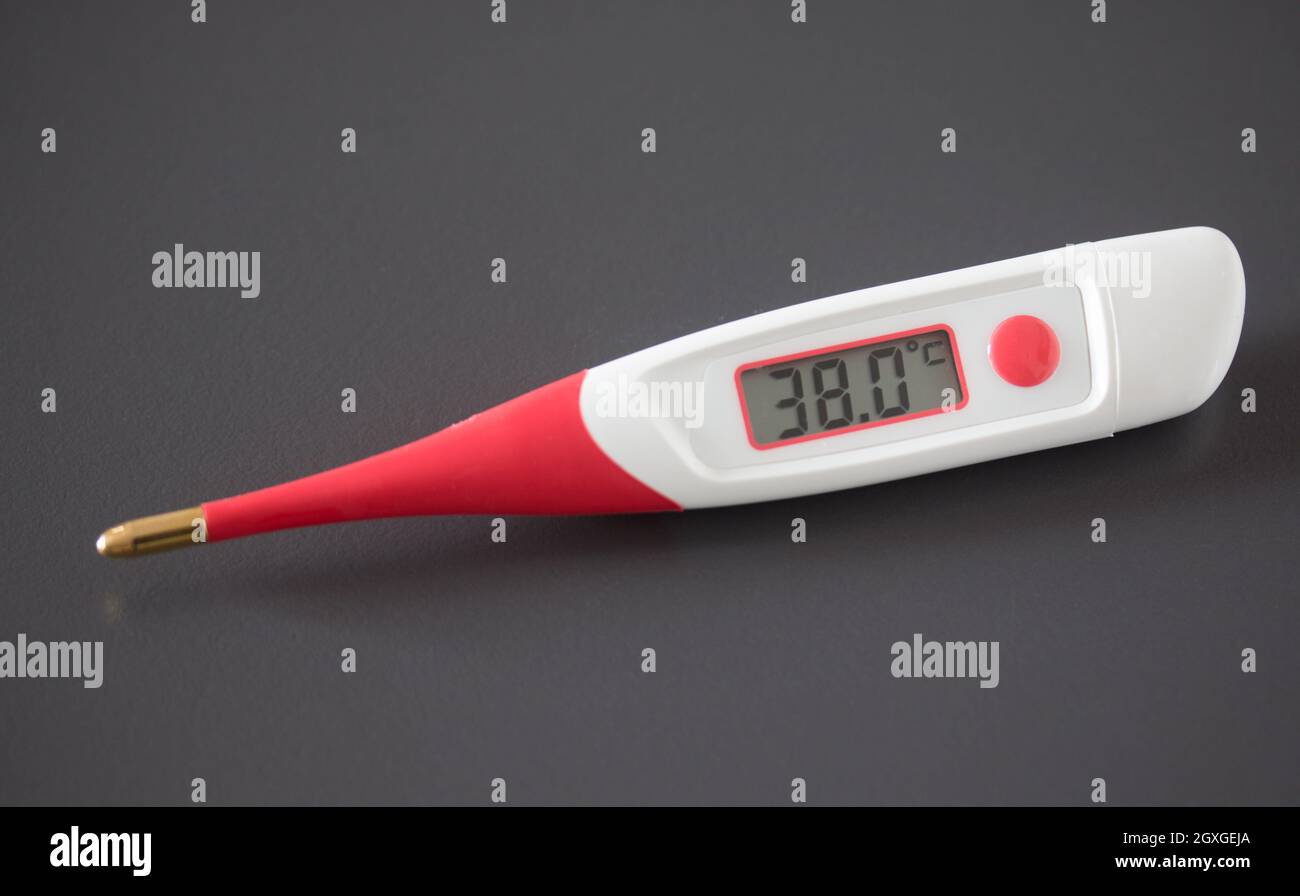 Fever thermometer and pills on the desk, 38 degrees Celsius on the display Stock Photo Alamy