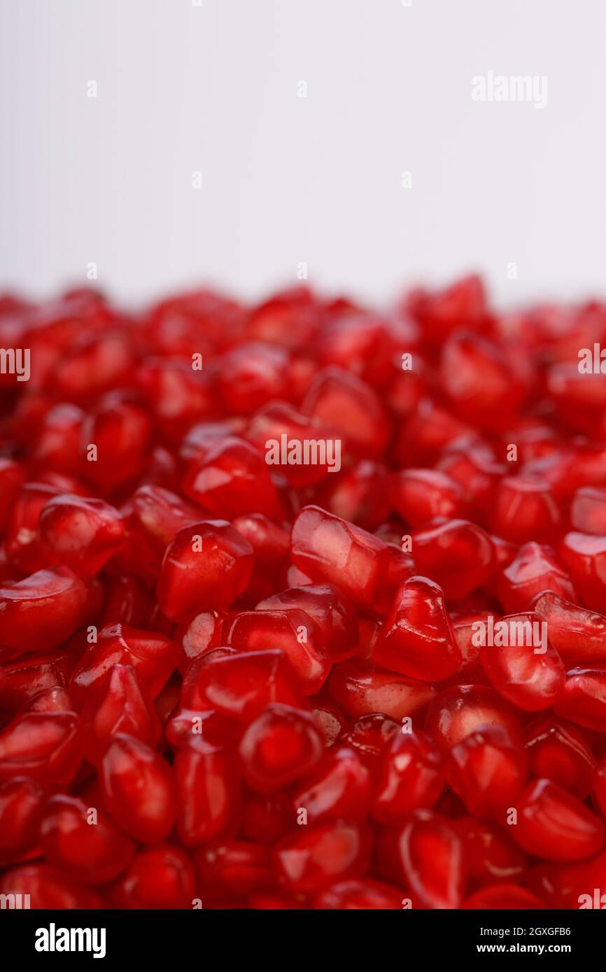 Fresh Pomegranate seed arranged in a square glass container with white background, isolated, close up. Stock Photo