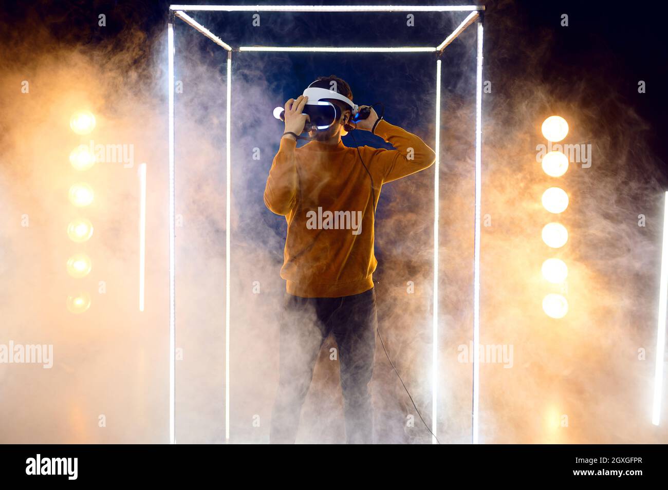 Luminus Vr Young man plays the game using virtual reality headset and gamepad in ...
