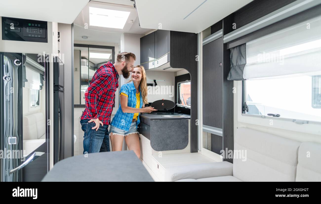 Woman and man testing interior of camper they want to buy or rent checking the kitchenette Stock Photo