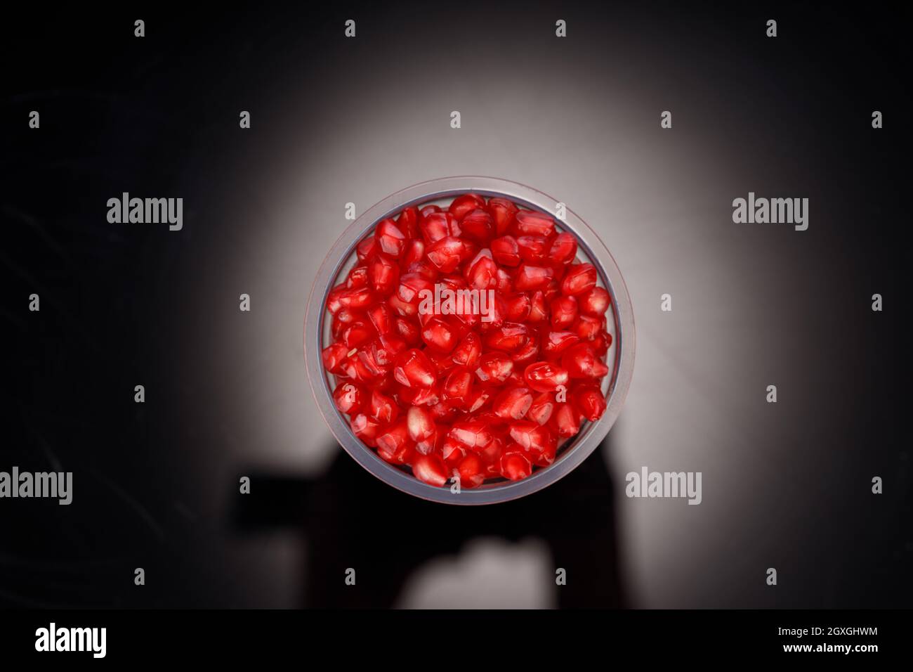 Fresh Pomegranate seed arranged in a glass  with black  background, isolated. Stock Photo