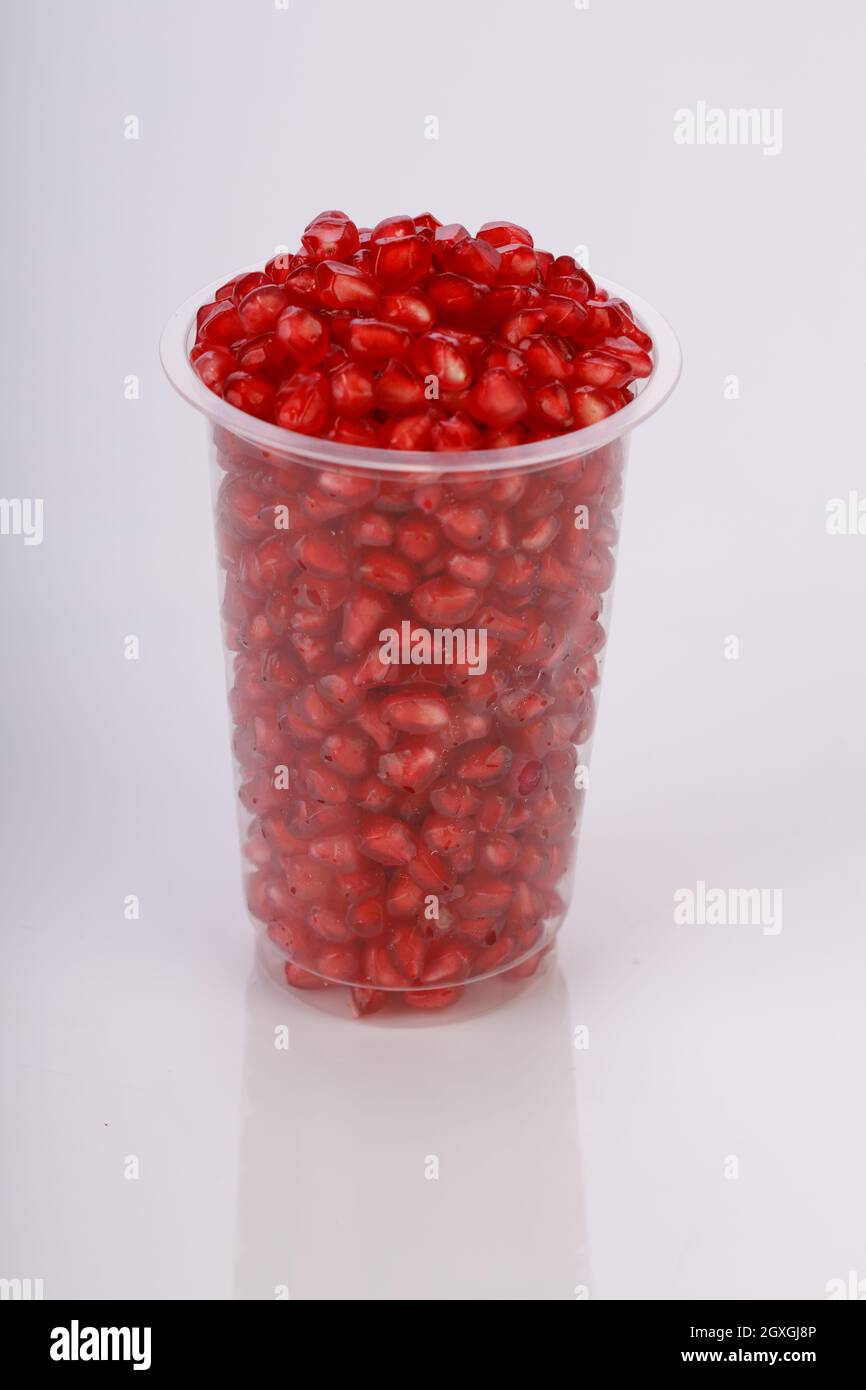 Fresh Pomegranate seed arranged in a  glass  with white background, isolated. Stock Photo
