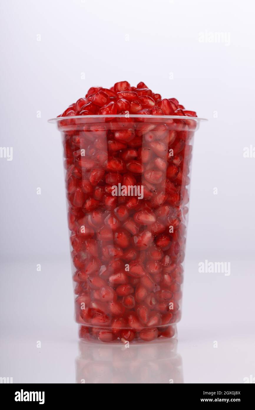 Fresh Pomegranate seed arranged in a  glass  with white background, isolated. Stock Photo