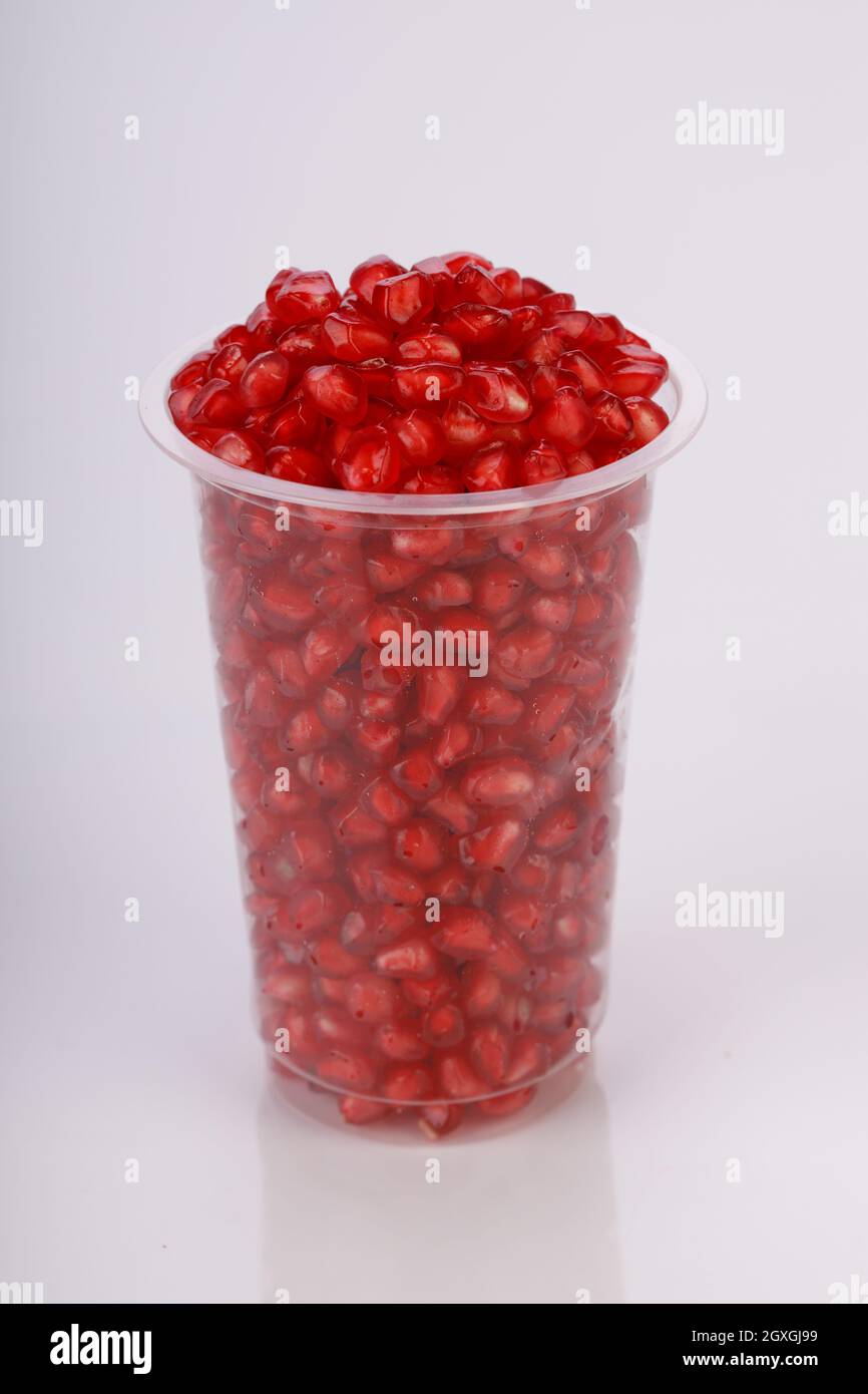 Fresh Pomegranate seed arranged in a  glass container with  white background, isolated. Stock Photo
