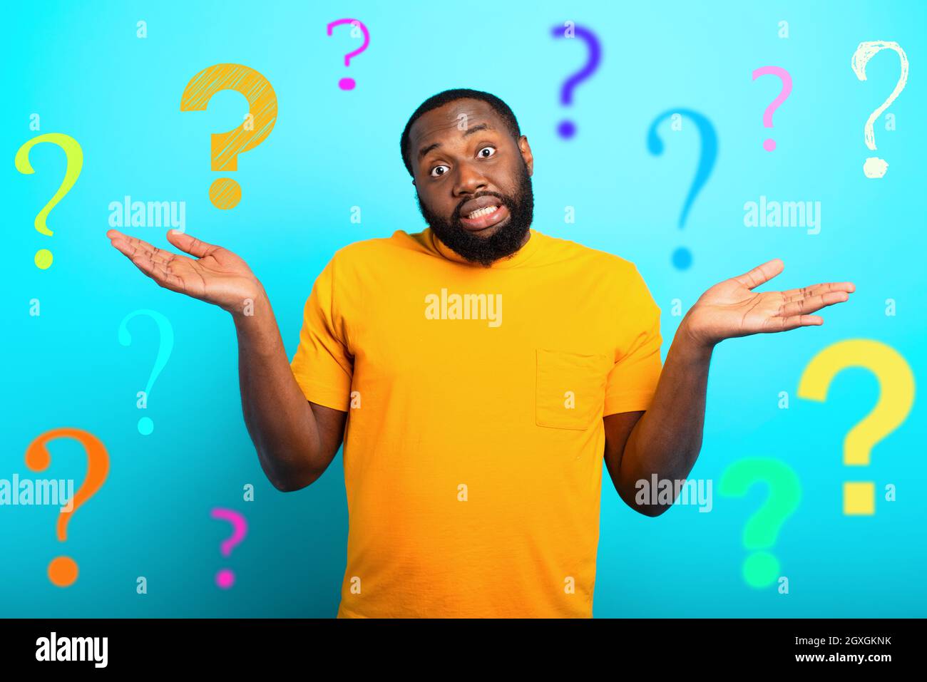 Confuse and pensive expression of a black boy with many questions . cyan colored background Stock Photo
