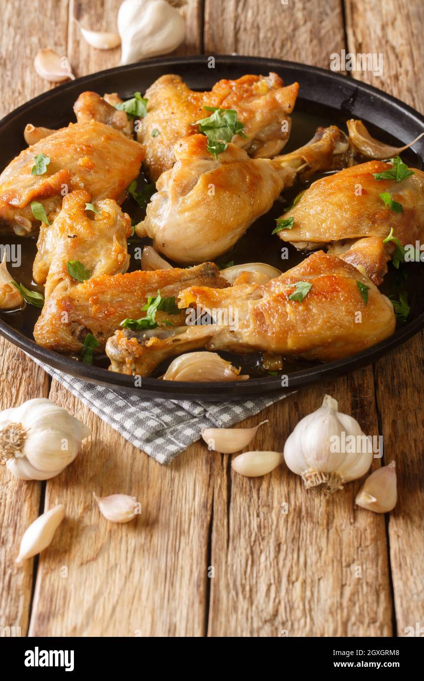 Pollo Al Ajillo Classic Spanish Fried Garlic Chicken close-up on a plate on the table. Vertical Stock Photo