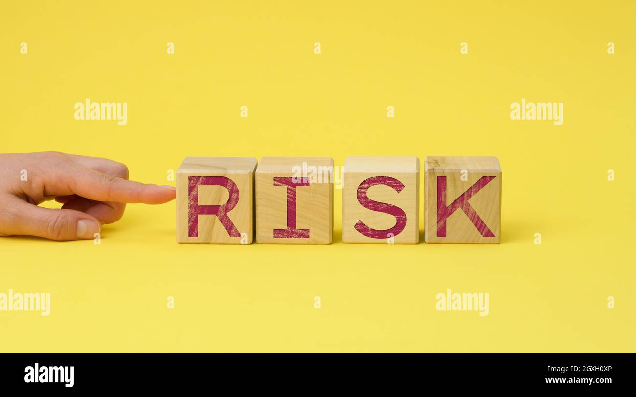 wooden cubes with the inscription risk on a yellow background. Risk ...