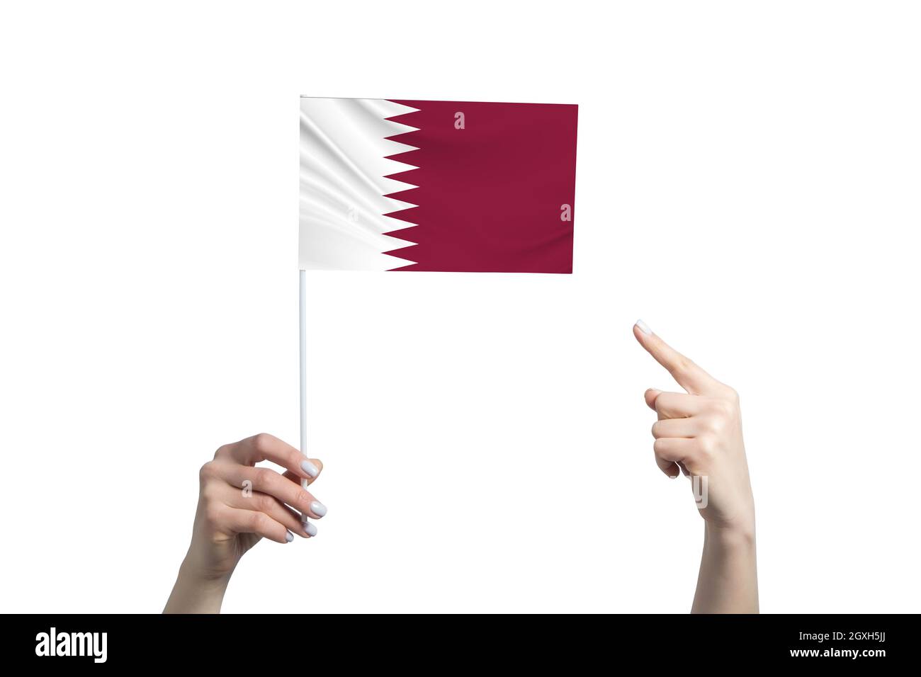 A beautiful female hand holds a Qatar flag to which she shows the