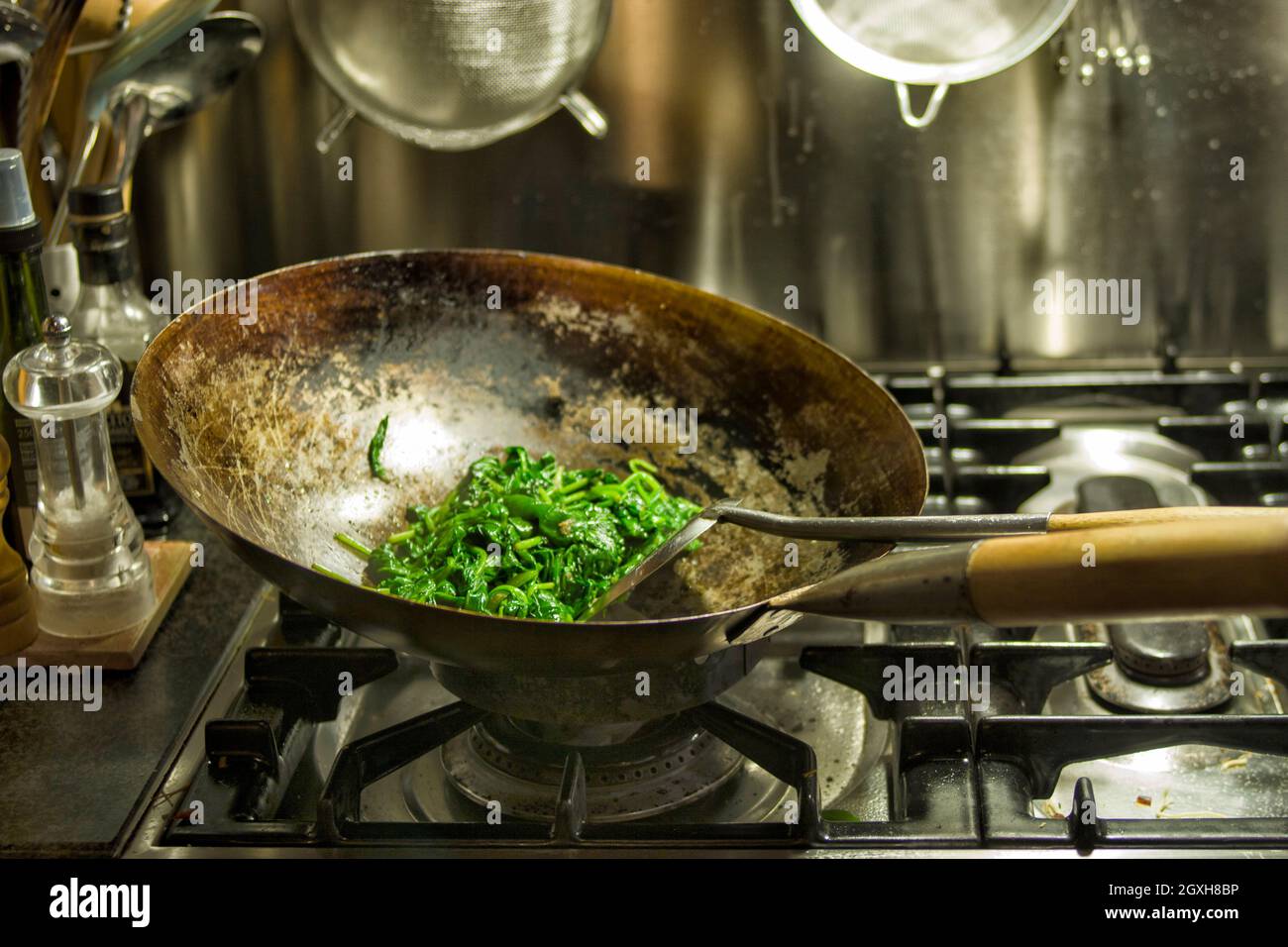 Stir frying spinach in kitchen Stock Photo Alamy