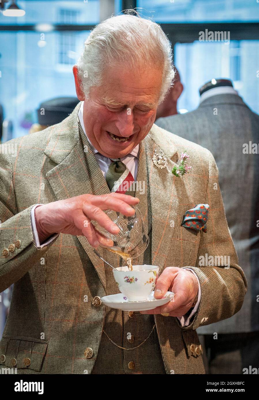 The Prince of Wales, known as the Duke of Rothesay when in Scotland, pours some whisky into his cup of tea at Gibbs Gentlemen's Outfitters during a visit to Inverurie Farmers Market and local shops around the town centre in Inverurie, Aberdeenshire. Picture date: Tuesday October 5, 2021. Stock Photo