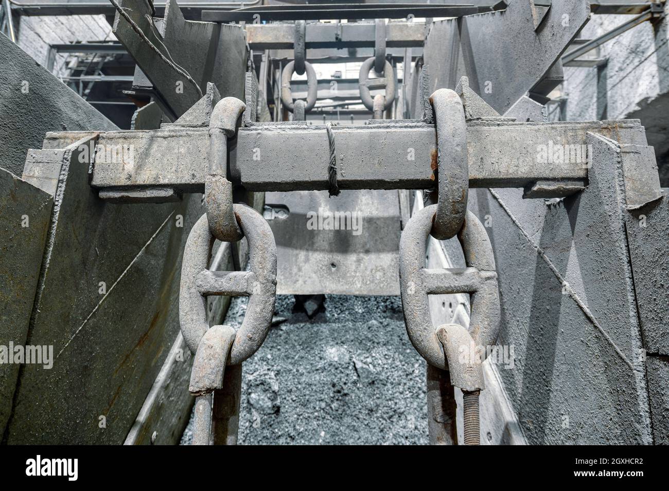 Metal ore vibrating conveyor, heavy duty steel plates and large chains Stock Photo
