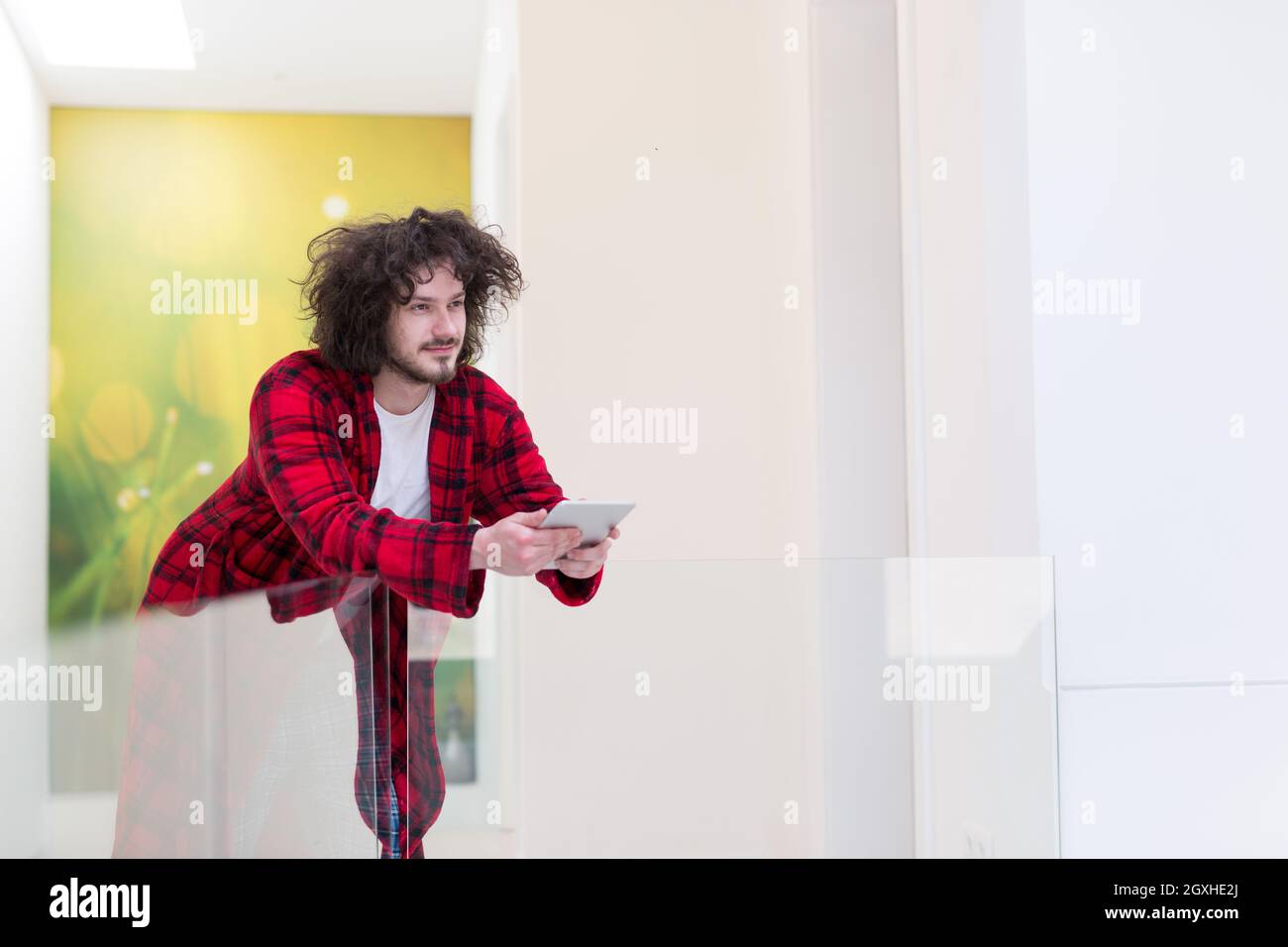 young freelancer in bathrobe working from home using tablet computer Stock Photo