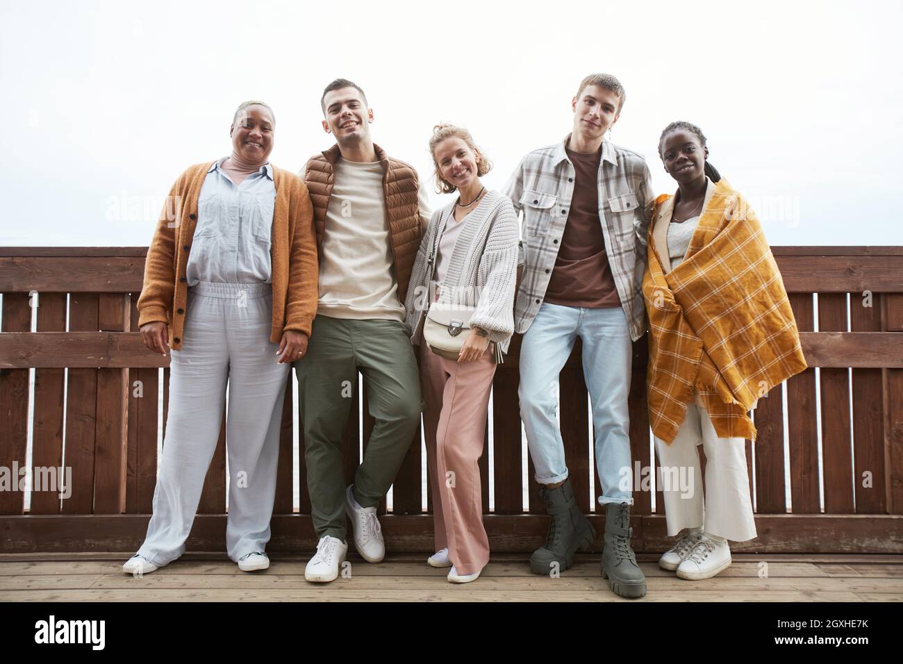 Full length portrait of diverse group of young people looking at camera while walking at seaside Stock Photo
