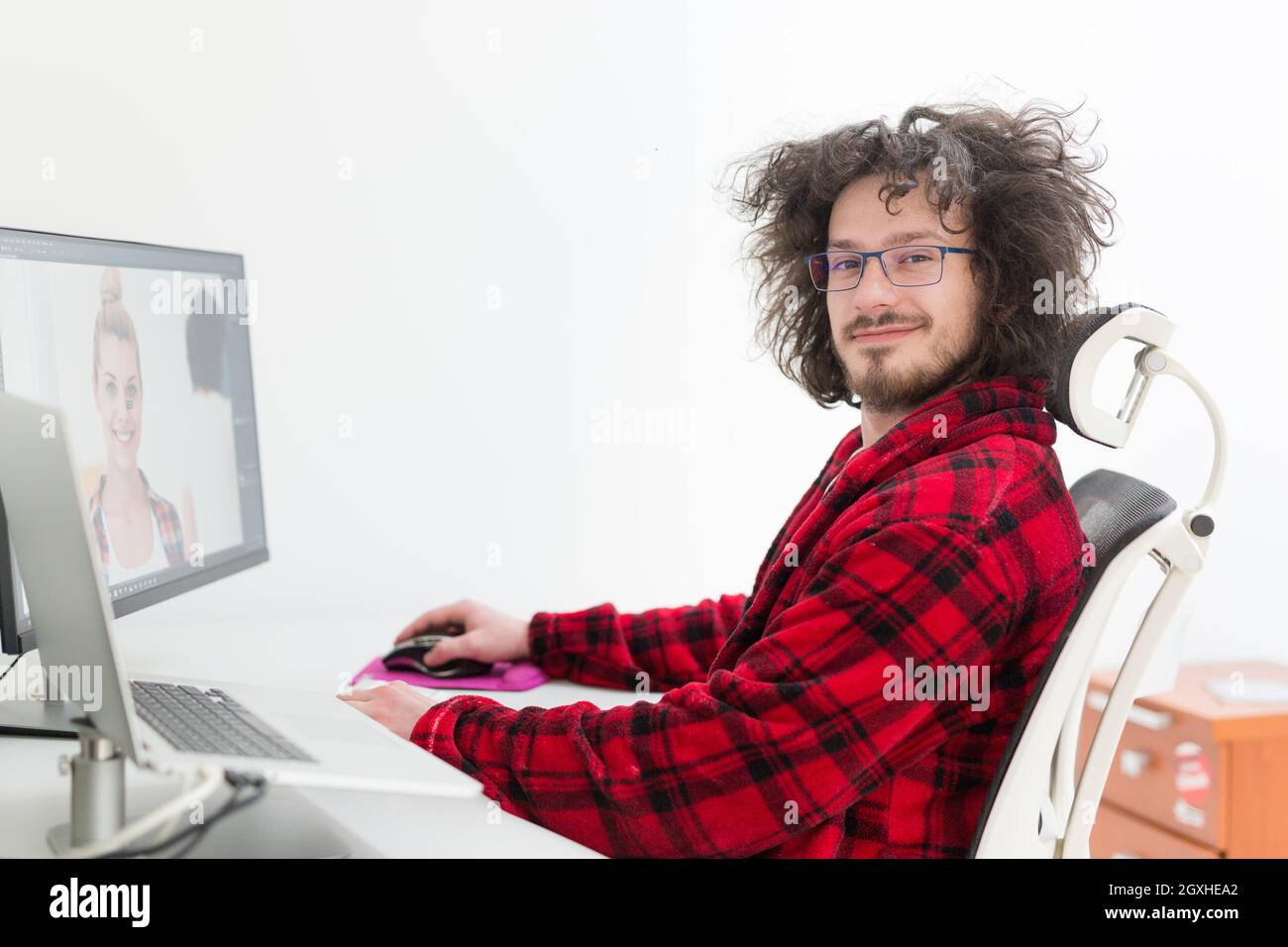 young graphic designer in bathrobe working at home office using computer Stock Photo
