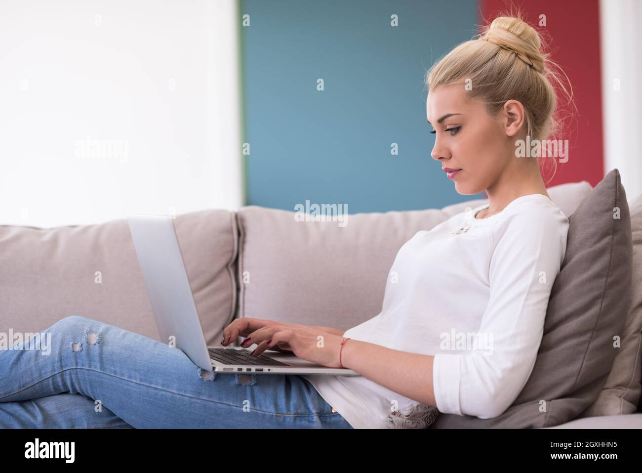 Young woman using her laptop computer in her luxury modern home ...