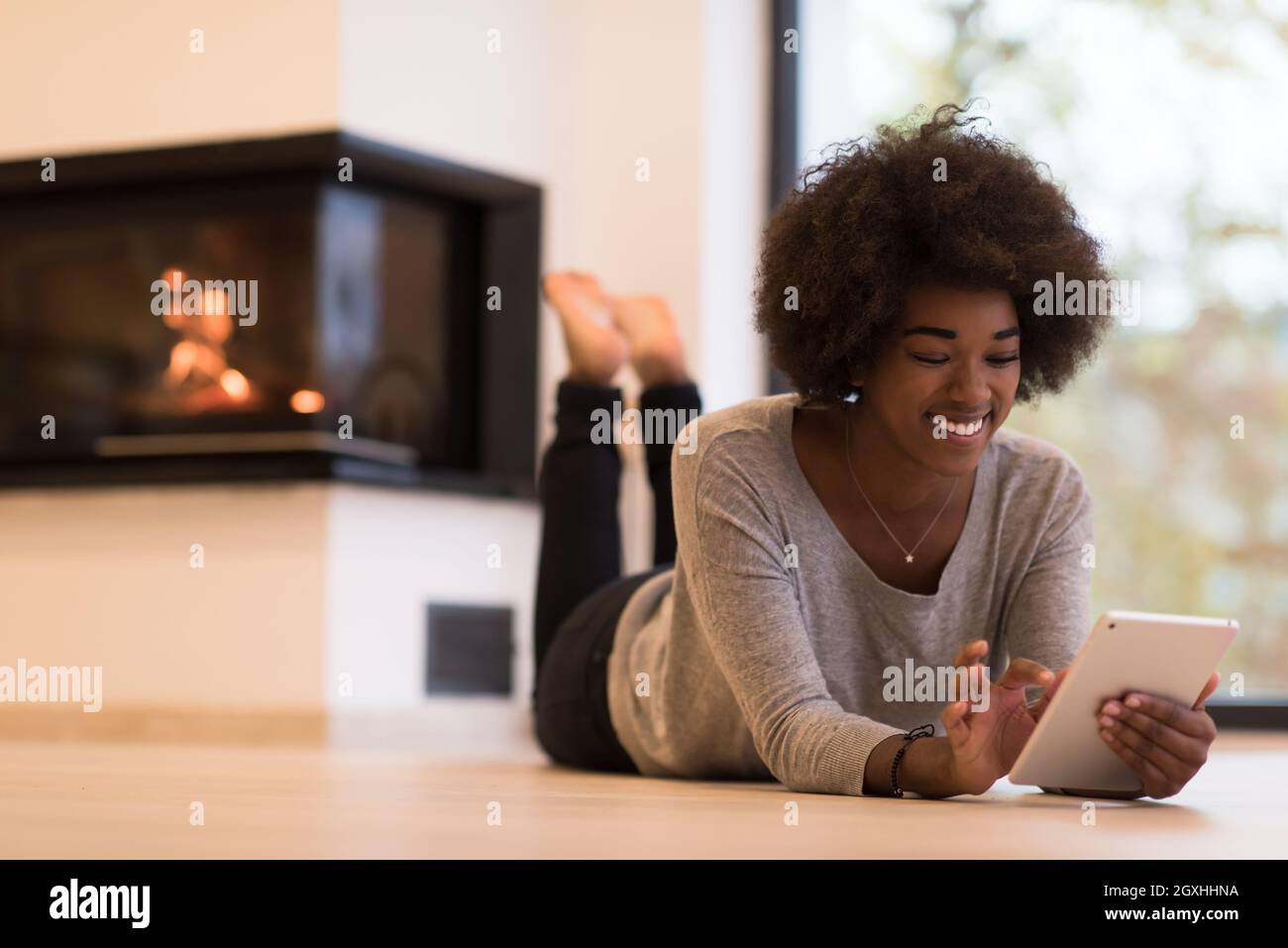 beautiful young black women using tablet computer on the floor of her ...