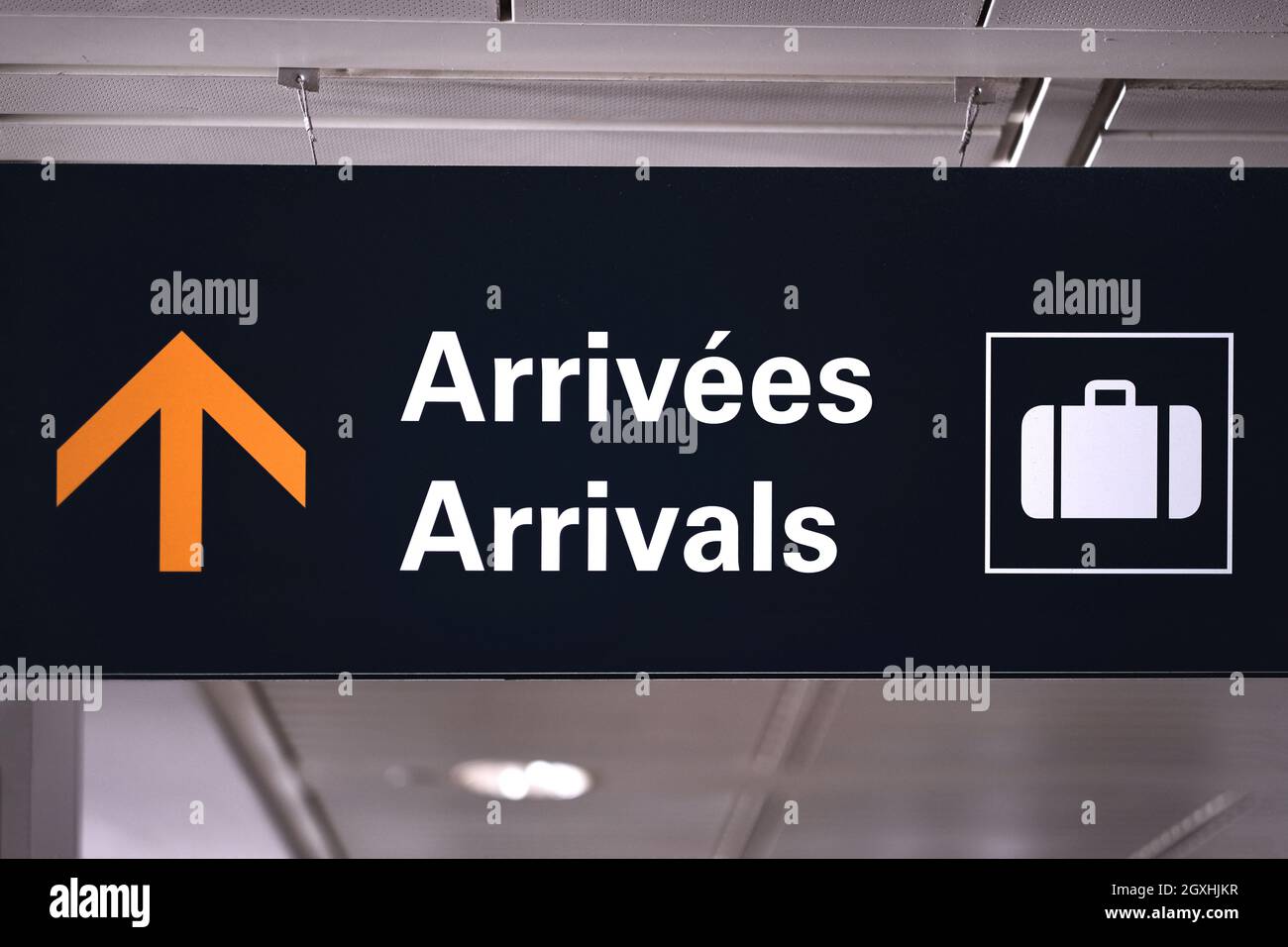 Bilingual arrivals sign board in english and french at airport terminal hall. Government open border for vaccinated international travellers visitors. Stock Photo