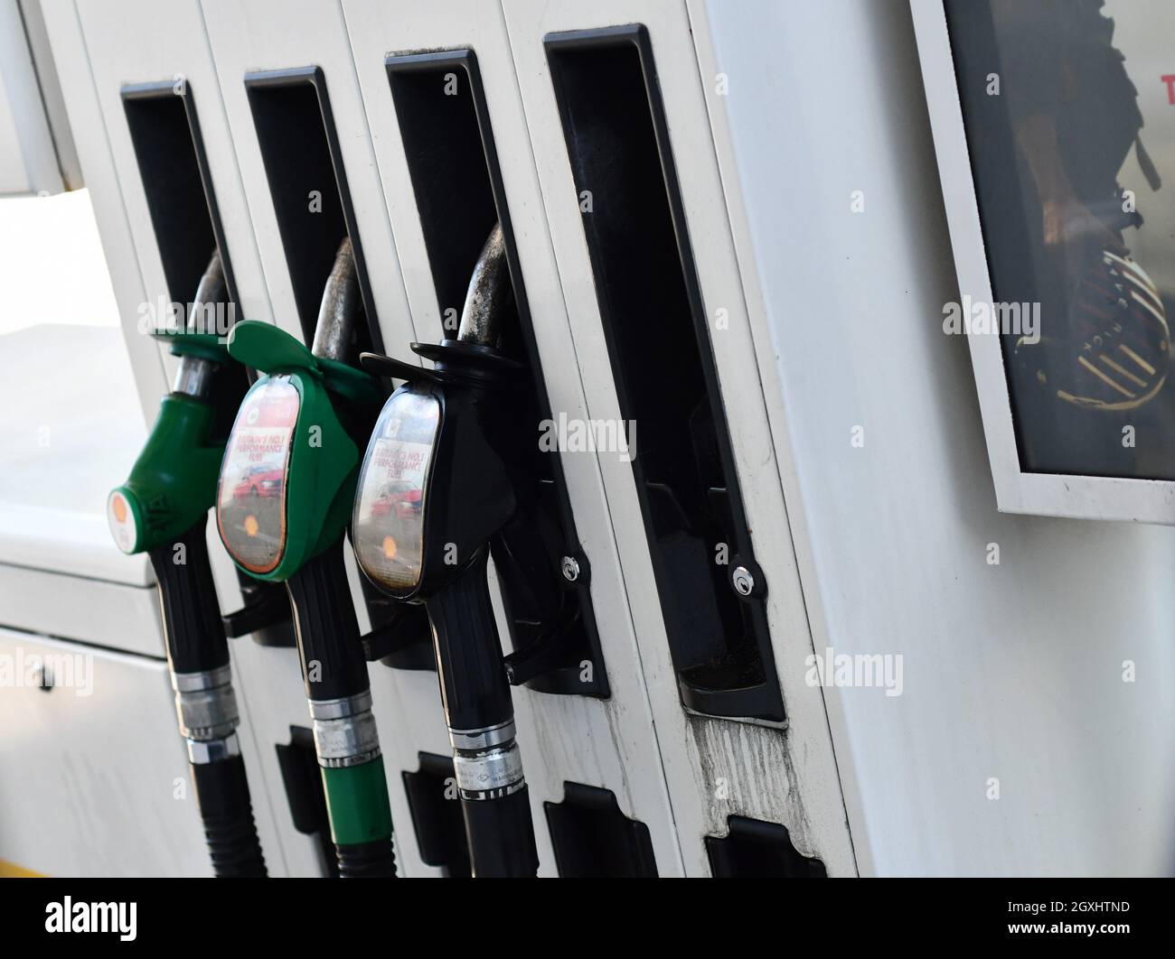 A bank of fuel pumps at a petrol station, unleaded petrol, premium petrol, premium diesel and standard diesel, one pump in use Stock Photo